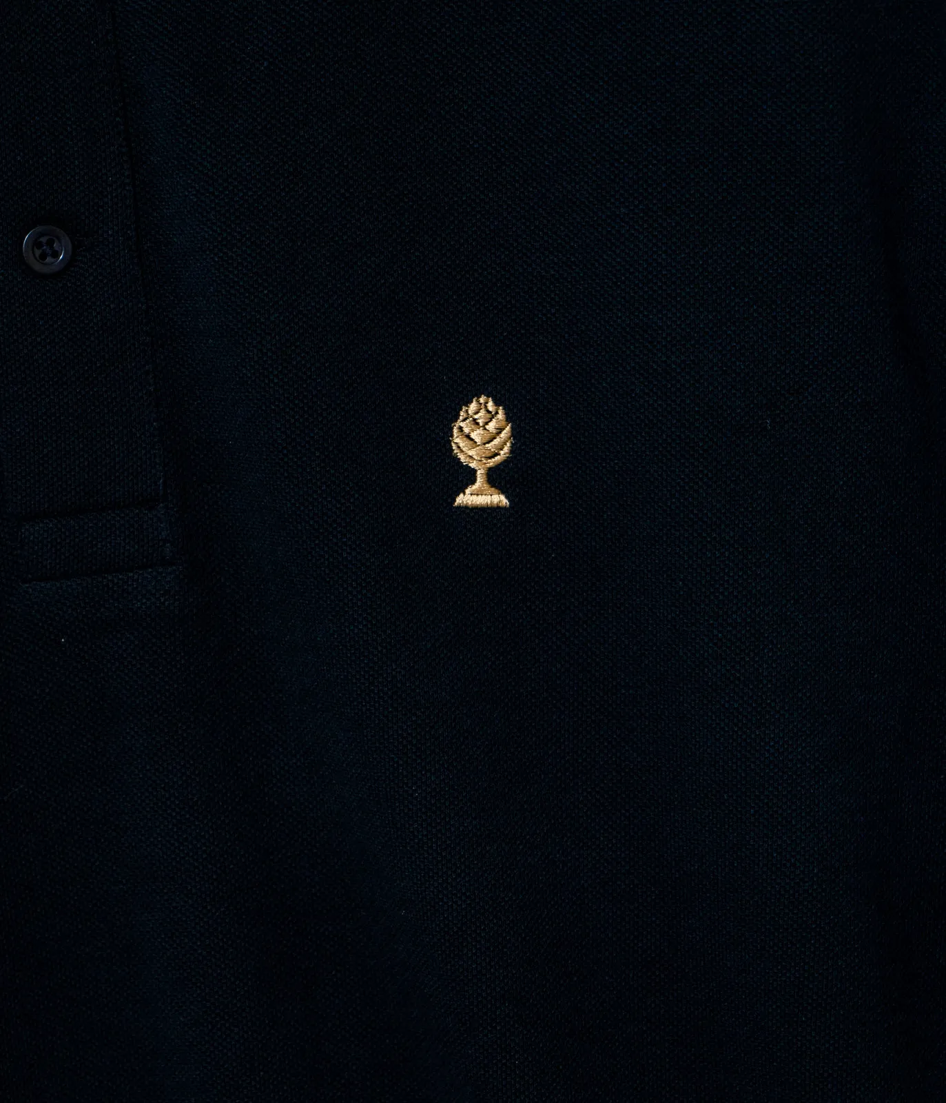 LOGO GOLD Poloshirt, Nahaufnahme der gold gestickten Zirbelnuss
